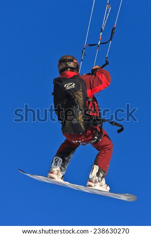 PASSO GIAU, ITALY - MARCH 11, 2012 - Snowkiter jumping with a snowboard in Passo Giau, Italy on a sunny winter day.