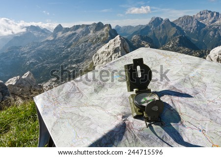 Finding your way with a compass and a map on the top of the mountain Rombon, Slovenia