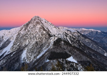 Mountain peak of Storzic (2136m) in sunset lit by the last sun rays of the day