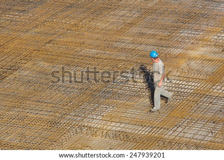 Construction worker inspecting steel mesh on a construction yard before pouring a concrete