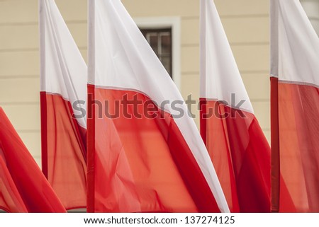 Polish flags on a background of wall.