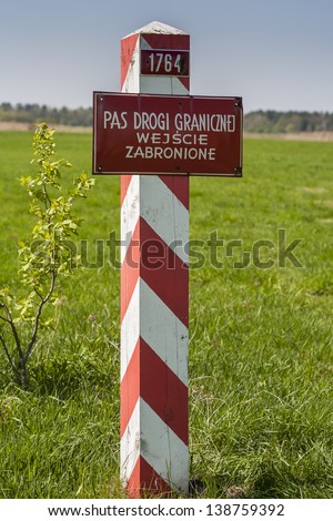 Border post on Poland border, meadow in the background.