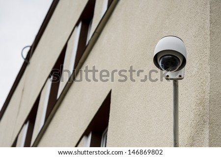 Security camera on a building set to the observations of the street and people.