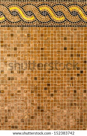Mosaic in ancient style stacked with tiny brown, yellow, blue tiles. Background with mosaic tiles with ornament.