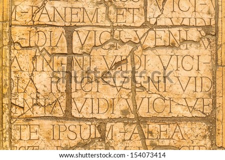 Cracked wall with Latin inscriptions and Roman letters, marble background.