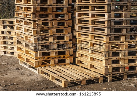 Wooden transport pallets in stacks ready for delivery. One palette in the foreground.