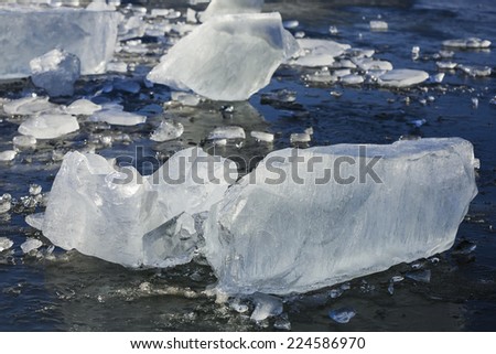 Shattered layers of cool blue ice sheets, background in blue.
