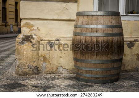 The old oak wine barrel, metal rims with rust, barrel standing on the street.