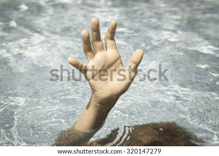 Sinking person calls for help. Hand drowning man sticking out of the water.