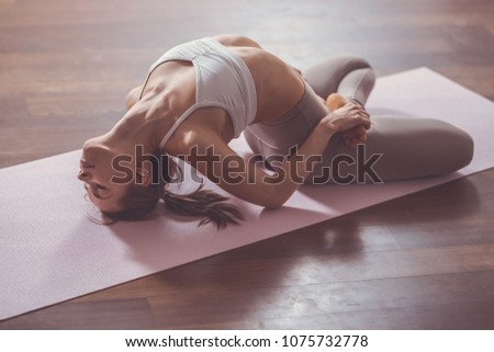 Young instructor practicing yoga on the floor