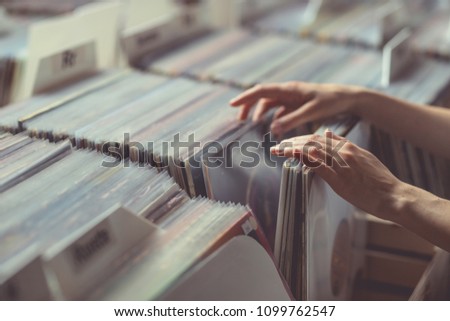 Women\'s hands browsing records in a vinyl record store