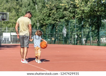 Father and son on the basketball court in summer