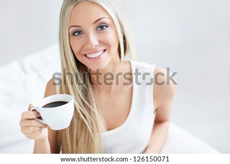 Beautiful young girl with a cup of coffee at home
