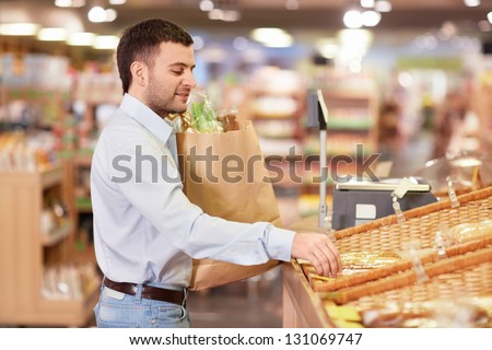 Young man with package of products in store