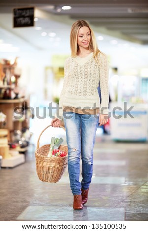 Young woman with a basket in a store