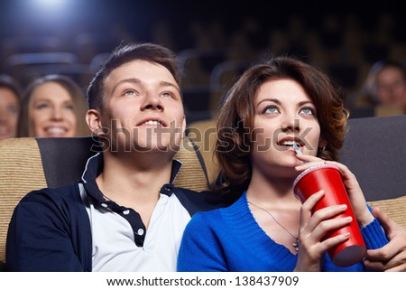 Smiling couple watching movie at the cinema