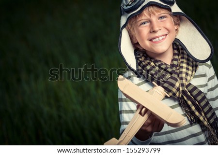 Smiling boy with wooden plane