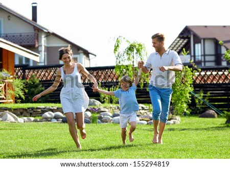 Happy family with a child by the house