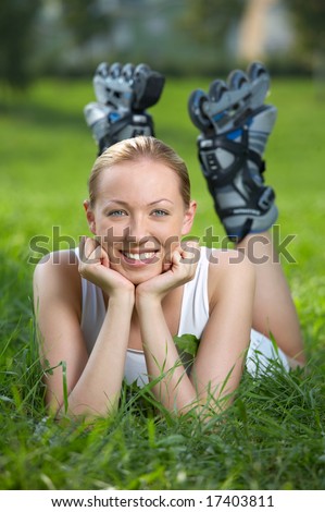 Girl with the roller fads put on feet lies on a grass