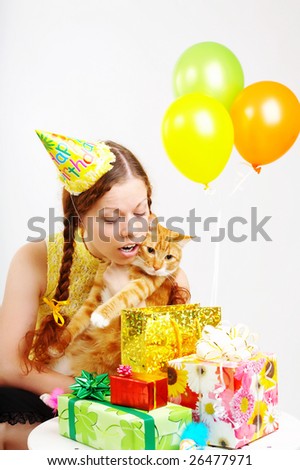 The cheerful birthday woman considers gifts with a cat in hands