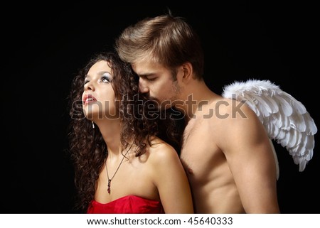Man with wings of an angel behind the beautiful girl on a black background