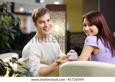 Happy smiling pair of the enamoured have dinner in cafe