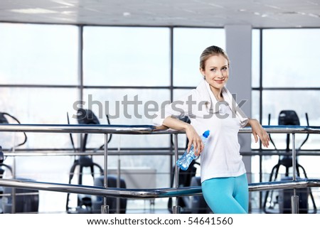 The attractive girl with a water bottle in fitness club