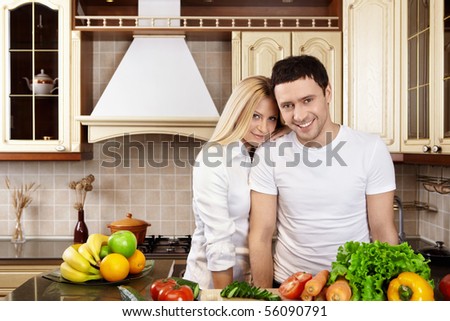 Young happy couple in white on kitchen