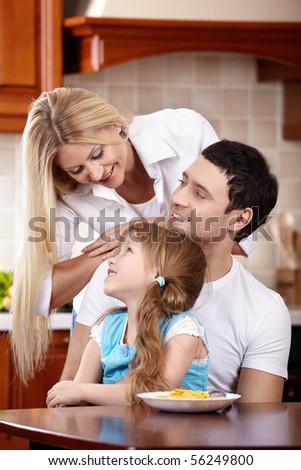 Parents and the small daughter on kitchen