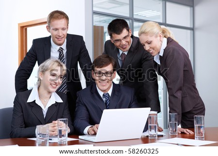 Employees of the office looking at laptop monitor