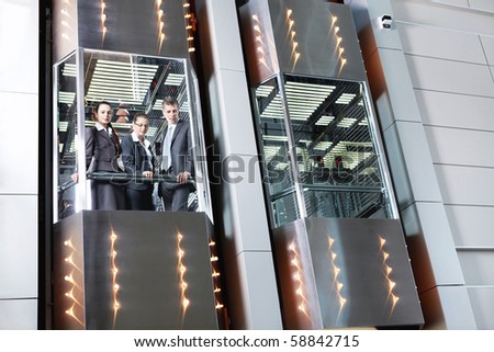 Business people traveling in the elevator looking down