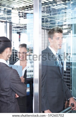 Young business people in suits in the elevator