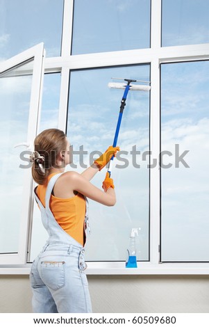 A young girl washes the window