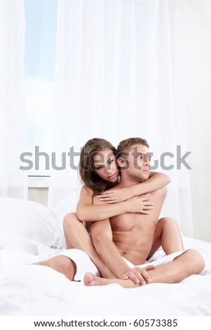 Young girl hugging a man in bed