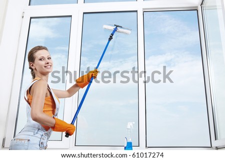 Young attractive girl washes window
