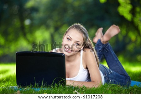 Attractive girl with a laptop in the park