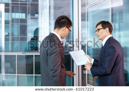 Two businessmen are discussed in the office