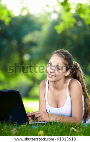 Young girl with laptop in the park