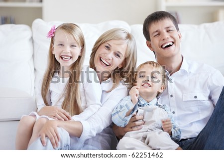 Smiling young parents with two children at home