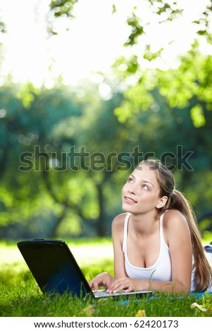 Young beautiful girl with a laptop in the park