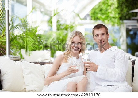 Young attractive couple drinking water in a restaurant