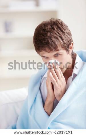 Sick man in a plaid with a handkerchief