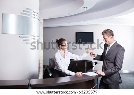 A young girl at the reception gave the keys to businessman