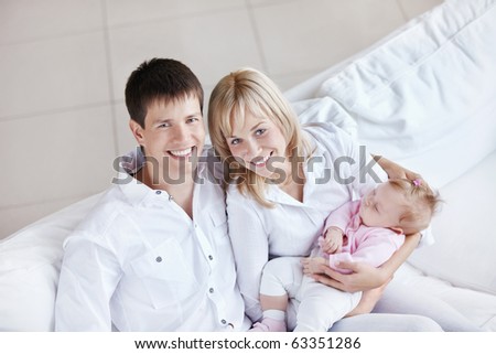 Happy young family with babies on the couch at home