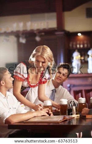 Young waitress brings the beer bar visitors