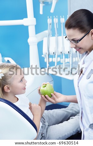Dentist gives the patient a green apple