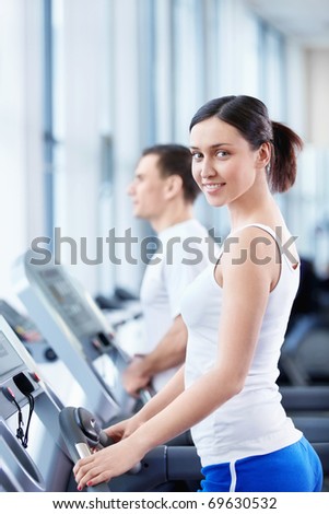 Young attractive girl on the treadmill