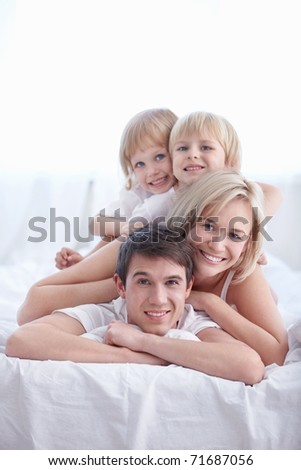 Family in their pajamas on the bed in the bedroom