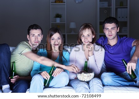 Young attractive people watch movies at home