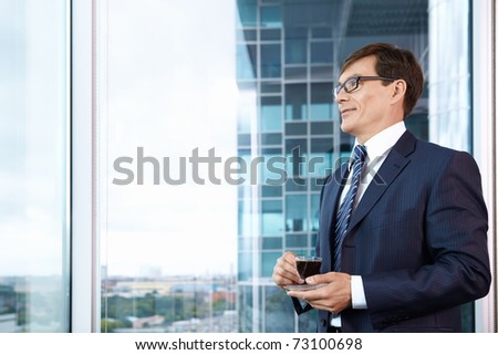 Business man with a cup of coffee in the office